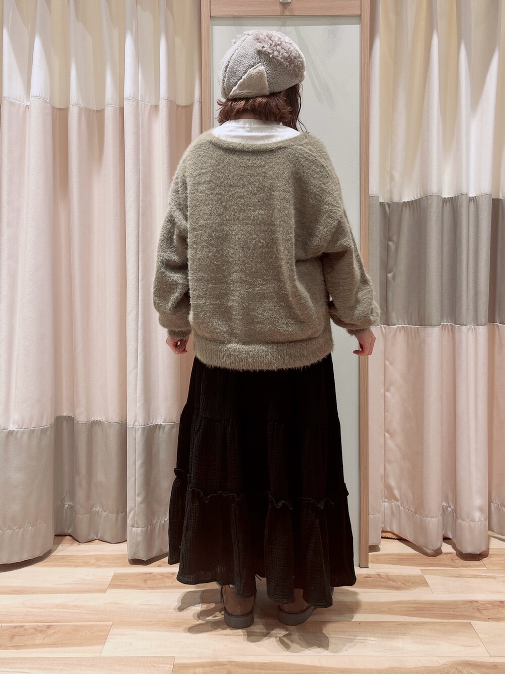 ブラウン系のカーディガン/ボレロ、ホワイト系のTシャツ/カットソー、ブラック系のスカートを着用したレディースの秋コーディネートの2枚目の写真