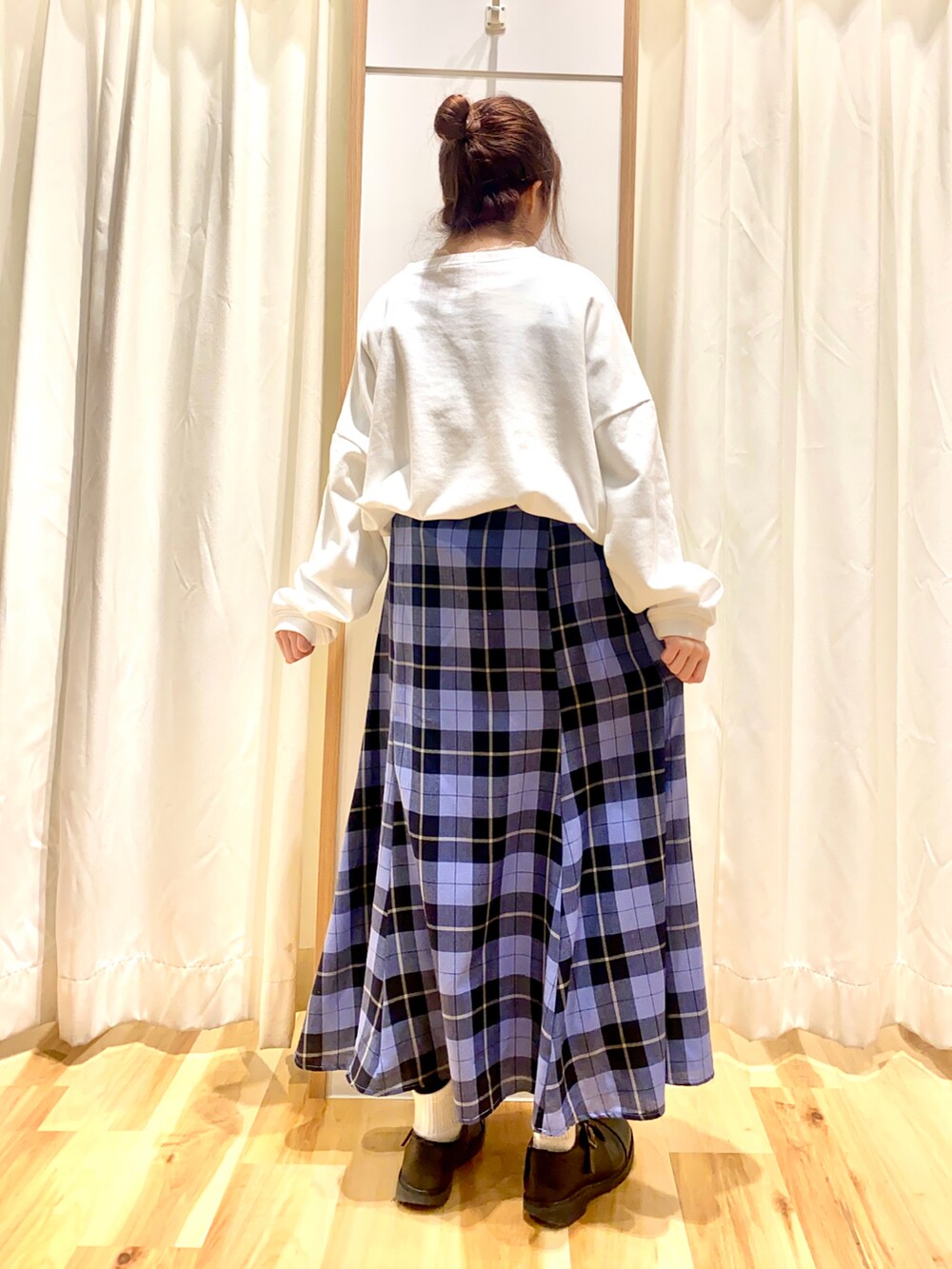 ホワイト系のスウェット、ブルー系のスカート、ホワイト系のTシャツ/カットソーを着用したレディースの春コーディネートの2枚目の写真