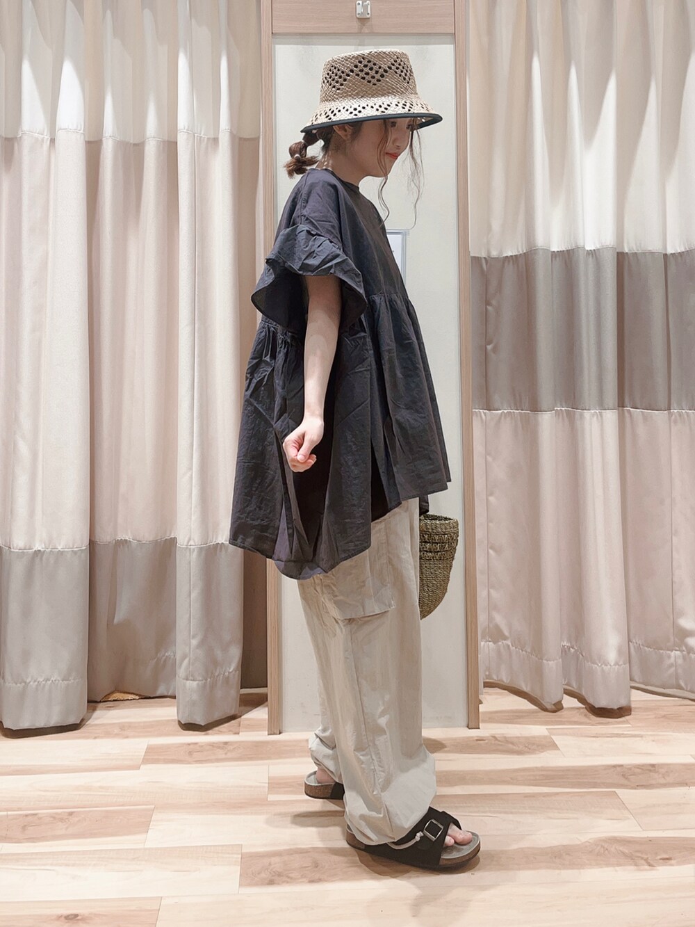 グレー系のチュニック、ベージュ系のカーゴパンツ、グリーン系のハンドバッグを着用したレディースの夏コーディネートの3枚目の写真