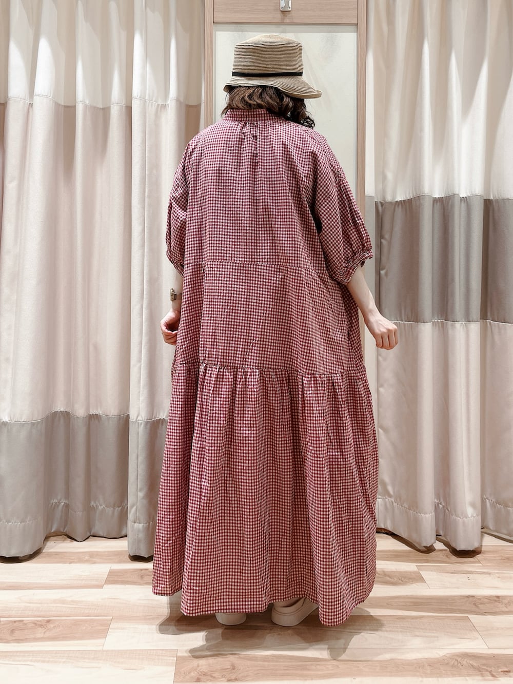 レッド系のワンピース、ブラウン系のTシャツ/カットソー、ホワイト系のスカートを着用したレディースの夏コーディネートの2枚目の写真