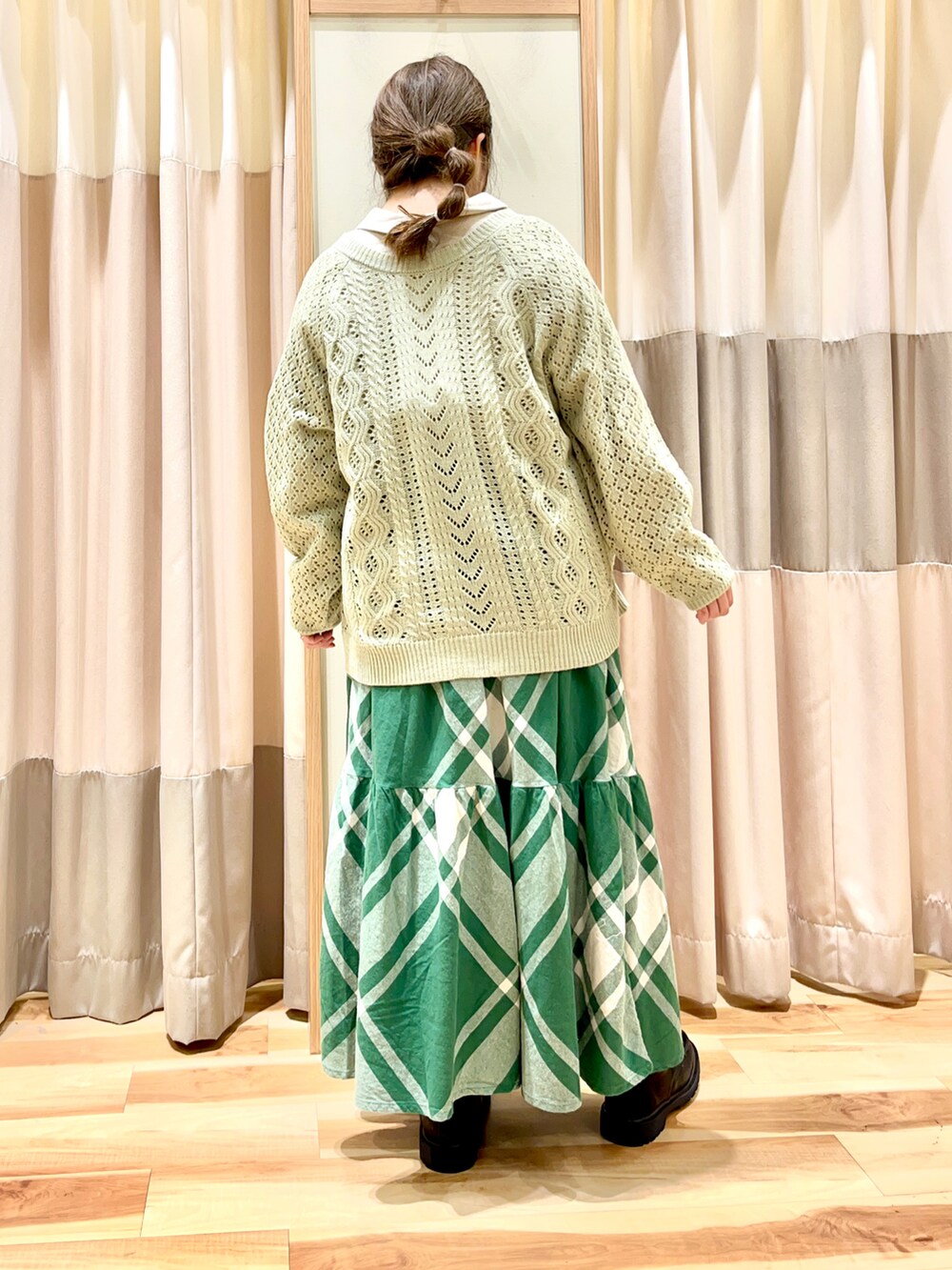 グリーン系のカーディガン/ボレロ、ホワイト系のシャツ/ブラウス、グリーン系のスカートを着用したレディースの冬コーディネートの2枚目の写真