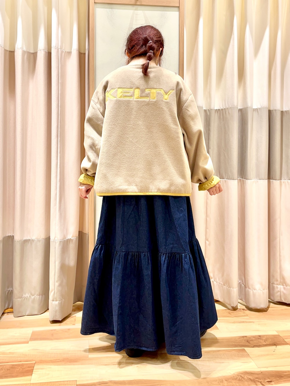 イエロー系のブルゾン、ブラック系のTシャツ/カットソー、ブルー系のデニムスカートを着用したレディースの秋コーディネートの4枚目の写真