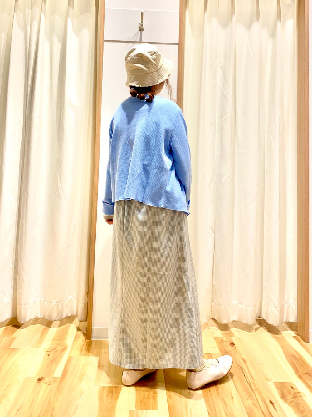 ホワイト系のカーディガン/ボレロ、ホワイト系のTシャツ/カットソー、グレー系のスカートを着用したレディースの春コーディネートの2枚目の写真