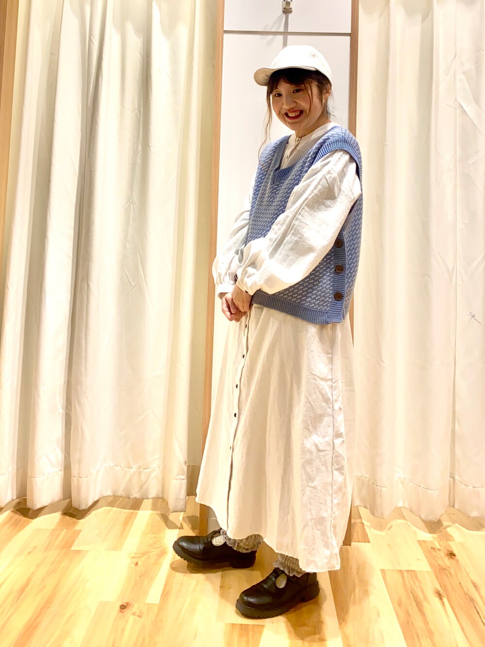 ブルー系のベスト、ホワイト系のワンピース、グレー系のその他パンツを着用したレディースの春コーディネートの5枚目の写真