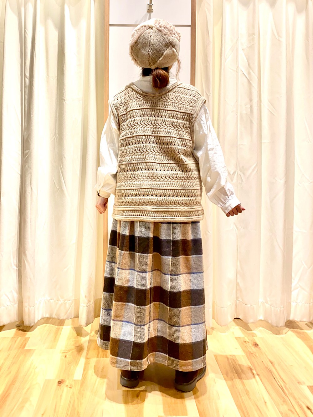 ベージュ系のベスト、ホワイト系のシャツ/ブラウス、ブラウン系のスカートを着用したレディースの冬コーディネートの2枚目の写真