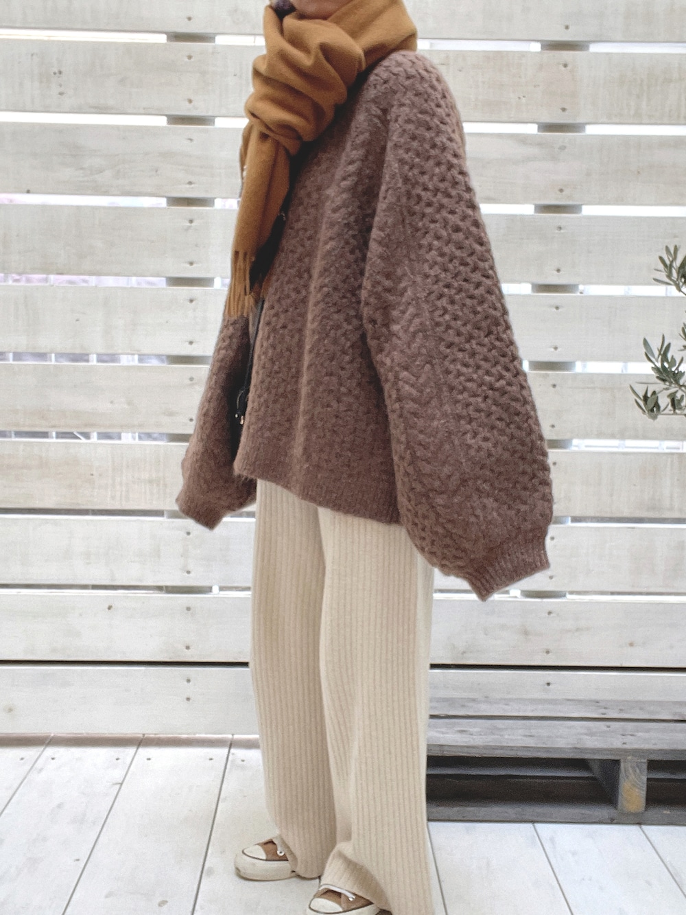 ベージュ系のその他パンツ、ブラウン系のニット/セーター、ブラウン系のスニーカーを着用したレディースの冬コーディネートの3枚目の写真