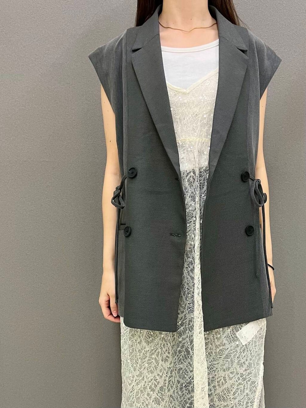 ホワイト系のTシャツ/カットソー、グレー系のベスト、シルバー系のその他シューズを着用したレディースの夏コーディネートの2枚目の写真