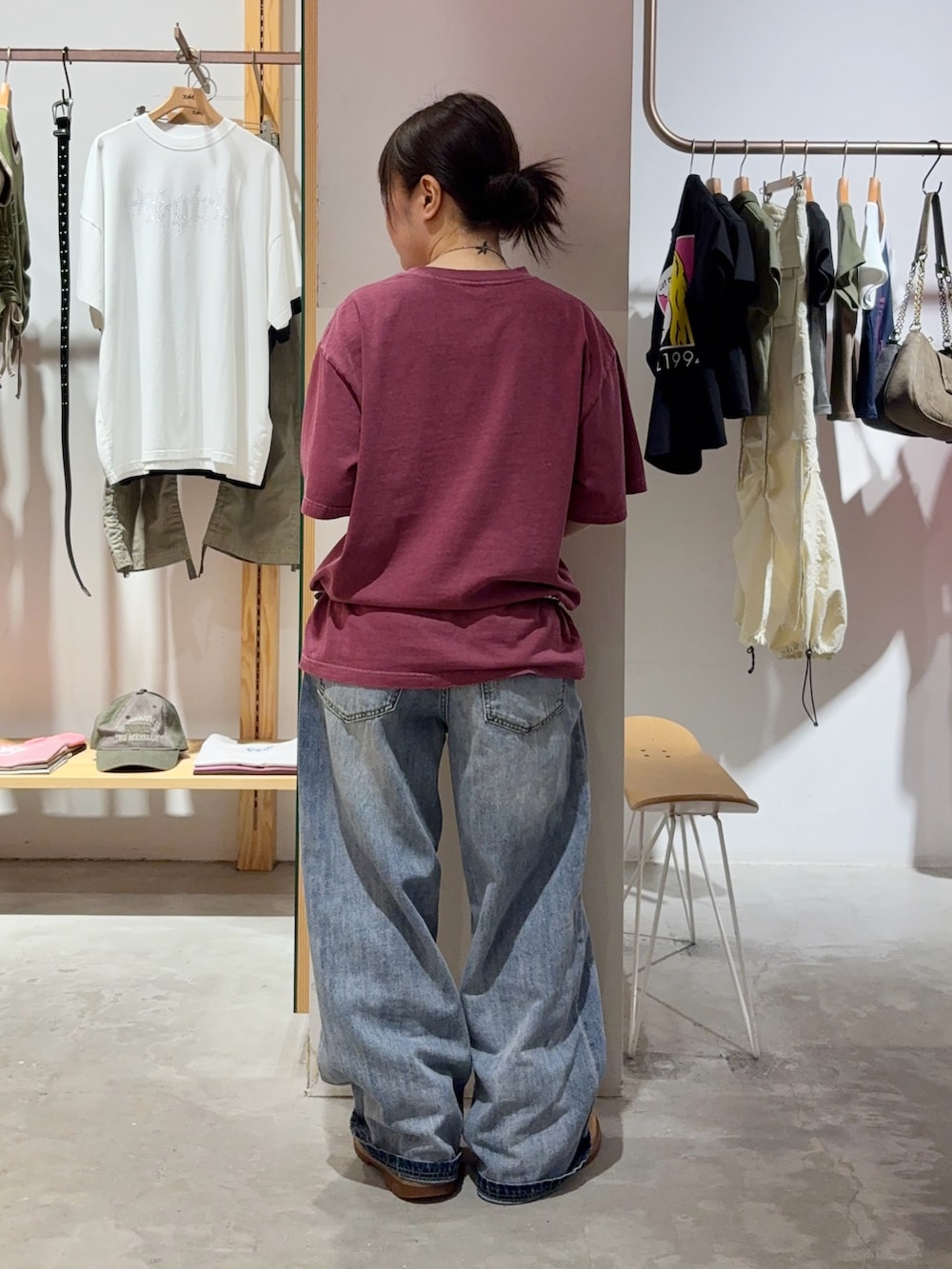 ブルー系のデニムパンツ、レッド系のTシャツ/カットソー、ブラック系のベルトを着用したレディースの夏コーディネートの2枚目の写真