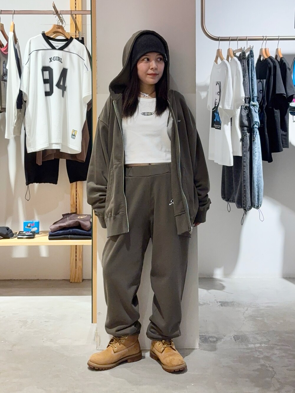 グリーン系のパーカー、グリーン系のスウェットパンツ、ブラック系のニットキャップ/ビーニーを着用したレディースの秋コーディネートの3枚目の写真