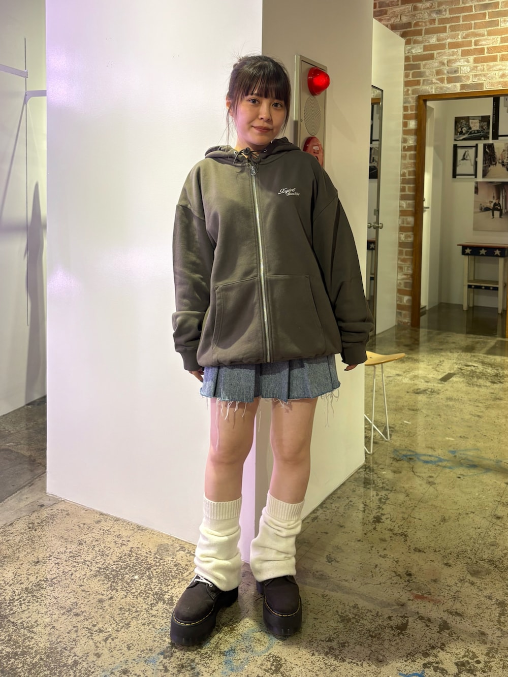 グリーン系のパーカー、ブルー系のデニムスカートを着用したレディースの夏コーディネートの2枚目の写真