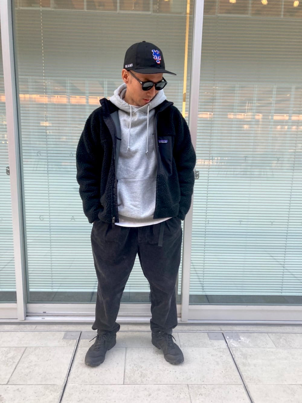 ブラック系のブルゾン、ブラック系のスニーカー、グレー系のトップスを着用したメンズの冬コーディネートの2枚目の写真