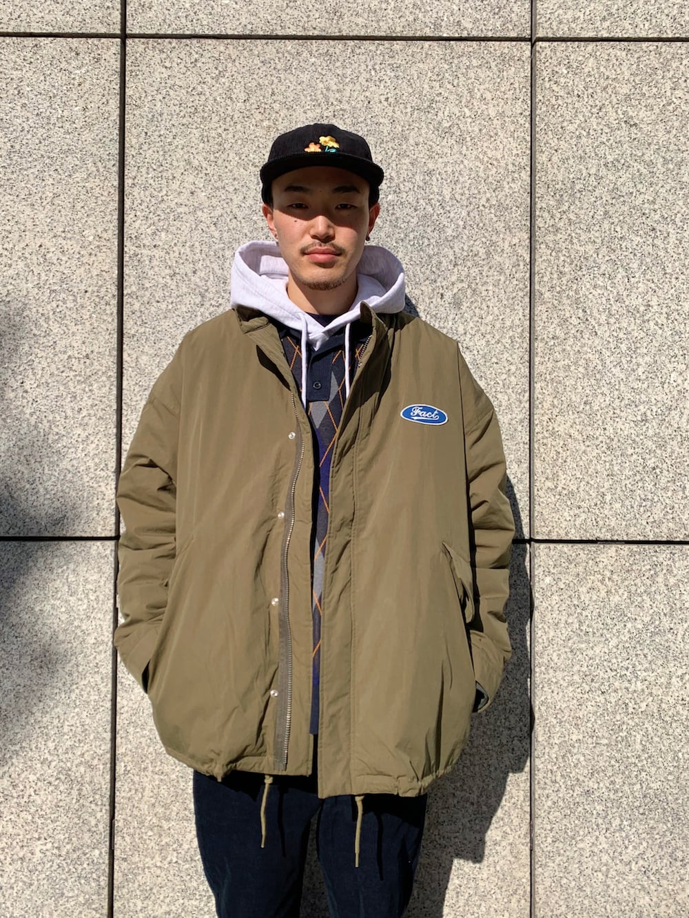 ブルー系のニット/セーター、グリーン系のモッズコート、ブラック系のその他パンツを着用したメンズの冬コーディネートの2枚目の写真