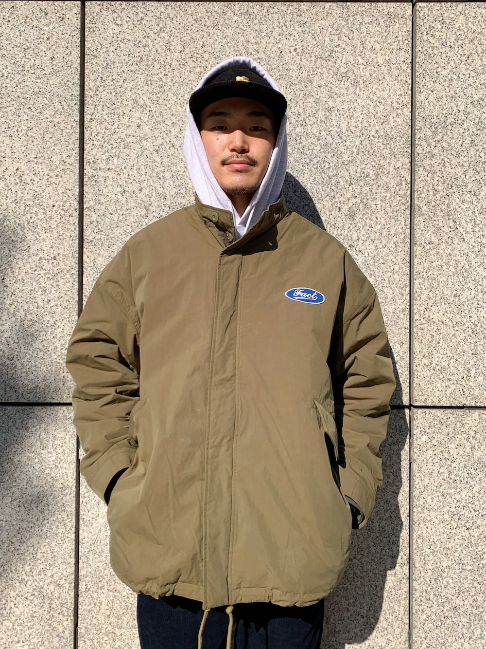 ブルー系のニット/セーター、グリーン系のモッズコート、ブラック系のその他パンツを着用したメンズの冬コーディネートの3枚目の写真