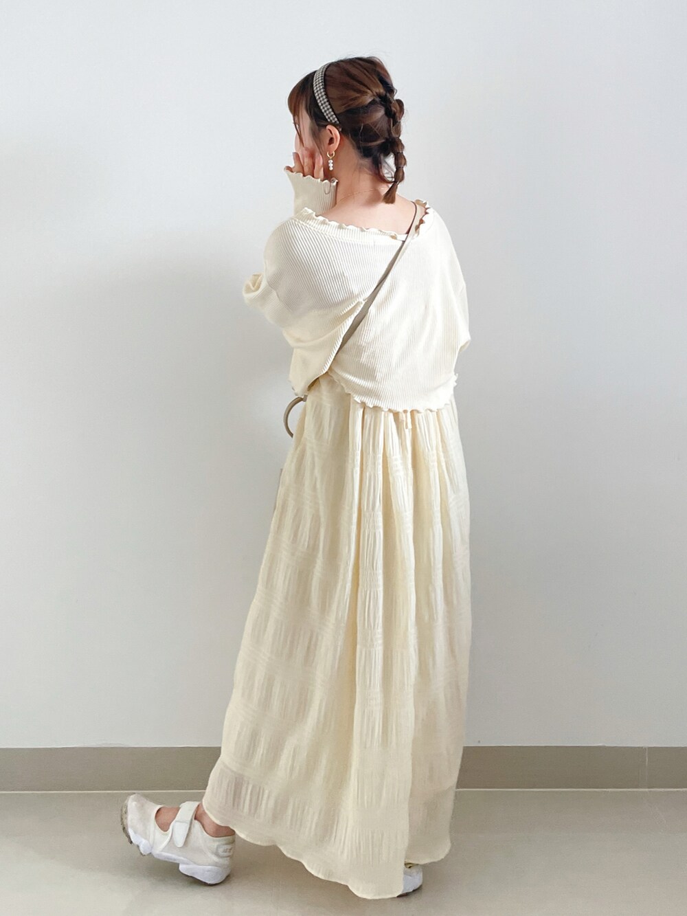 ホワイト系のワンピース、ベージュ系のサンダル、ホワイト系のバッグを着用したレディースの秋コーディネートの2枚目の写真