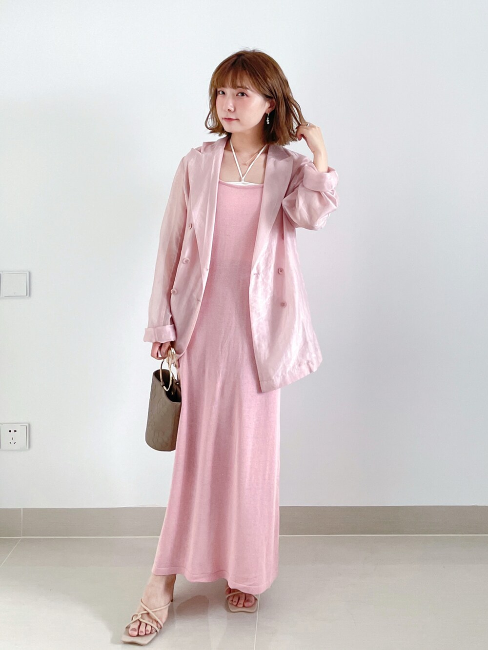 ピンク系のテーラードジャケット、ピンク系のワンピース、ホワイト系のキャミソールを着用したレディースの秋コーディネートの2枚目の写真