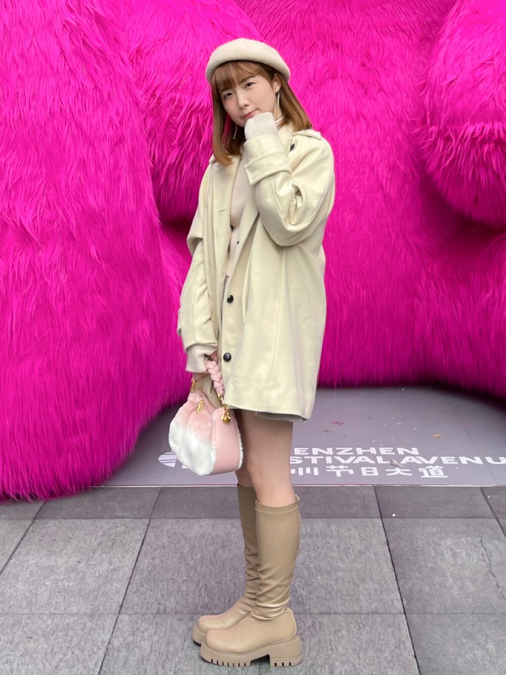 ホワイト系のその他アウター、ベージュ系のブーツ、ホワイト系のニット/セーターを着用したレディースの冬コーディネートの2枚目の写真