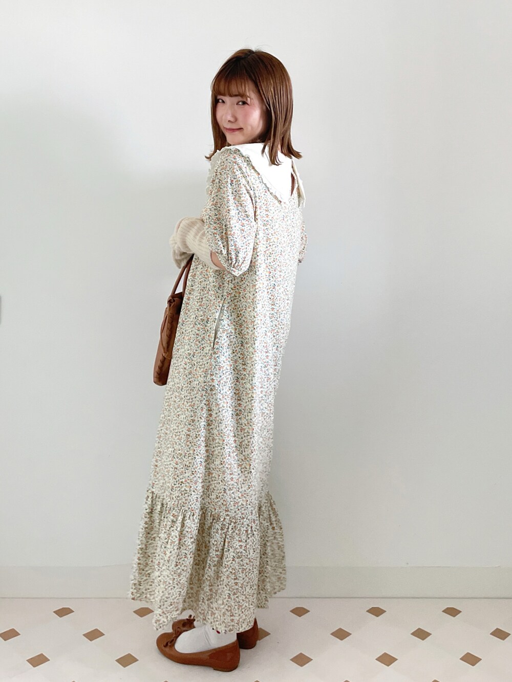 イエロー系のワンピース/ドレス、ブラウン系のショルダーバッグ、イエロー系のバレエシューズを着用したレディースの秋コーディネートの3枚目の写真