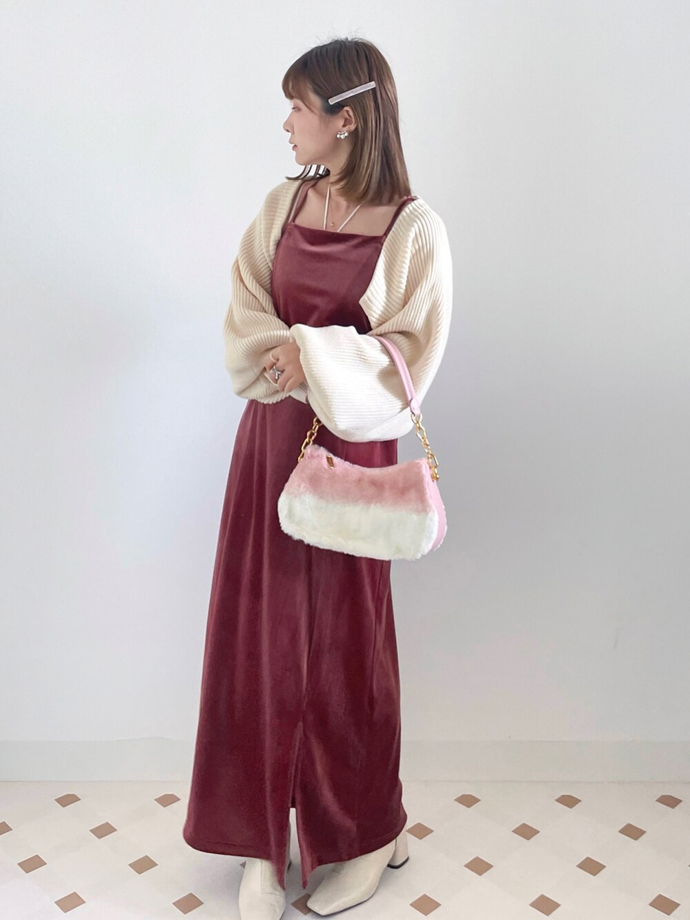 ホワイト系のカーディガン/ボレロ、ピンク系のワンピース、ホワイト系のブーツを着用したレディースの冬コーディネートの2枚目の写真