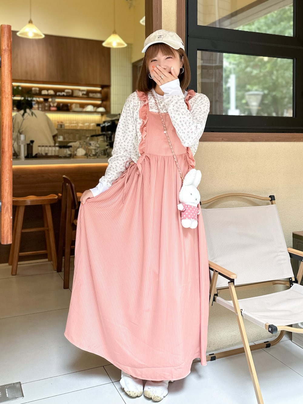 ピンク系のワンピース、ピンク系のTシャツ/カットソー、ベージュ系のスニーカーを着用したレディースの冬コーディネートの2枚目の写真