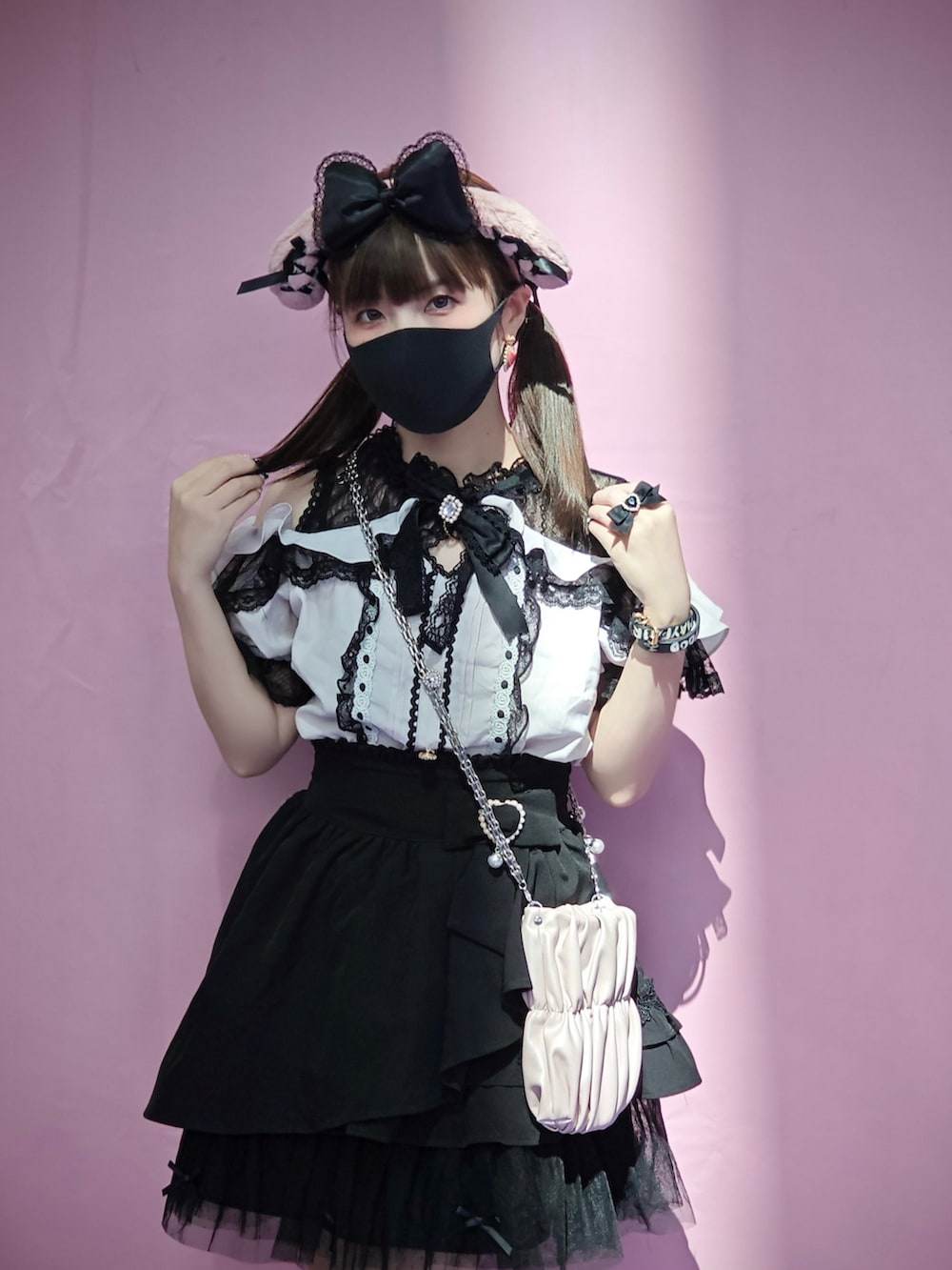 ピンク系のトップス、ブラック系のスカートを着用したレディースの夏コーディネートの2枚目の写真