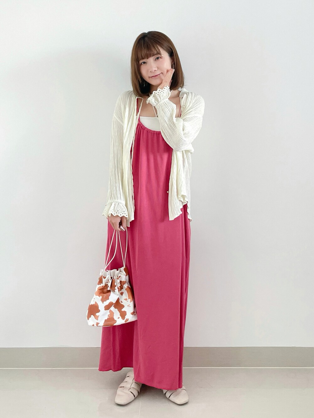 ピンク系のワンピース、ホワイト系のショルダーバッグ、ホワイト系のサンダルを着用したレディースの夏コーディネートの2枚目の写真