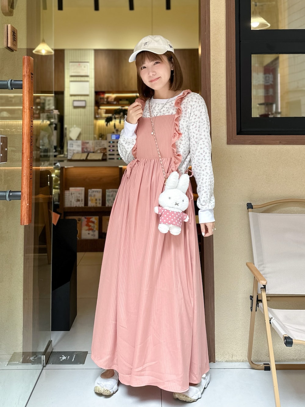 ピンク系のワンピース、ピンク系のTシャツ/カットソー、ベージュ系のスニーカーを着用したレディースの冬コーディネートの3枚目の写真
