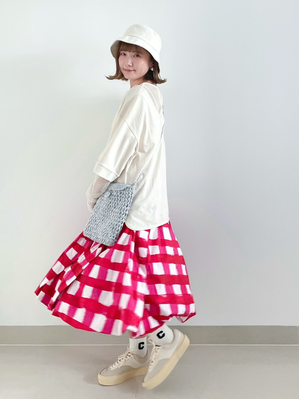 ホワイト系のTシャツ/カットソー、グレー系のショルダーバッグ、レッド系のスカートを着用したレディースの夏コーディネートの3枚目の写真