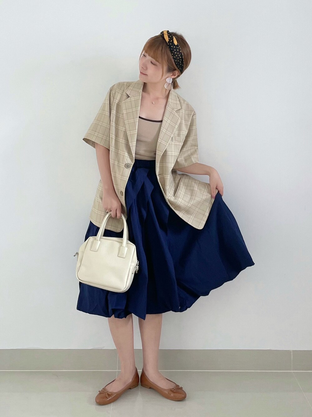 ブルー系のスカート、ベージュ系のトップス、イエロー系のバレエシューズを着用したレディースの夏コーディネートの3枚目の写真