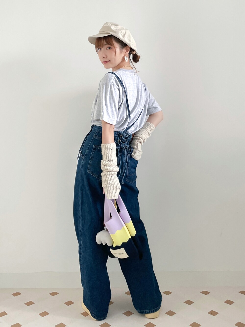 グレー系のTシャツ/カットソー、ブルー系のサロペット/オーバーオール、ベージュ系のキャップを着用したレディースの冬コーディネートの2枚目の写真