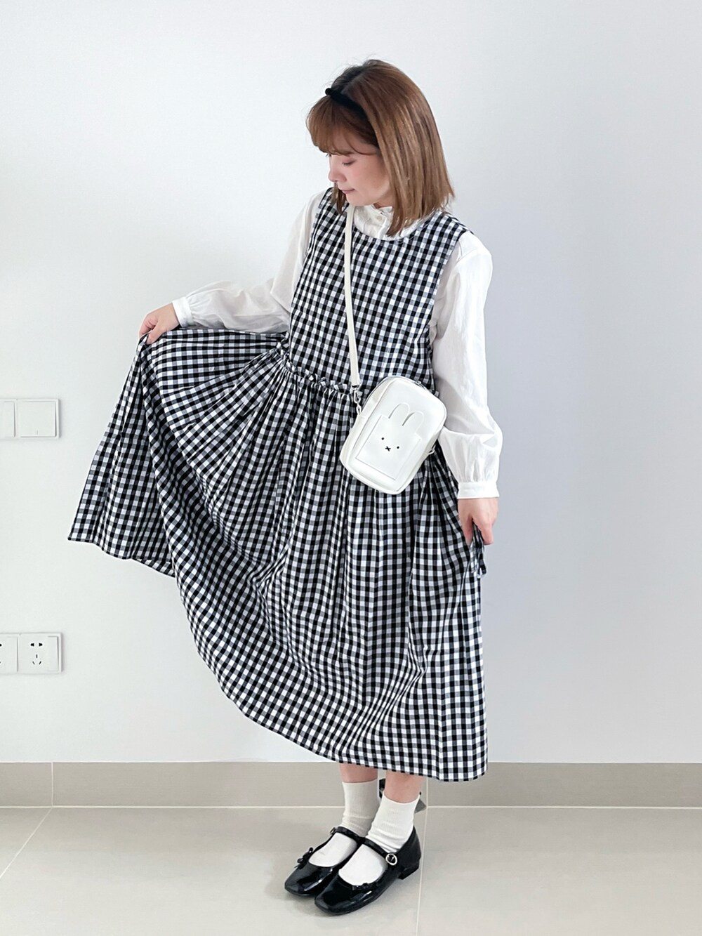 ホワイト系のバッグ、ブラック系のシューズ、ブラック系のワンピース/ドレスを着用したレディースの秋コーディネートの2枚目の写真