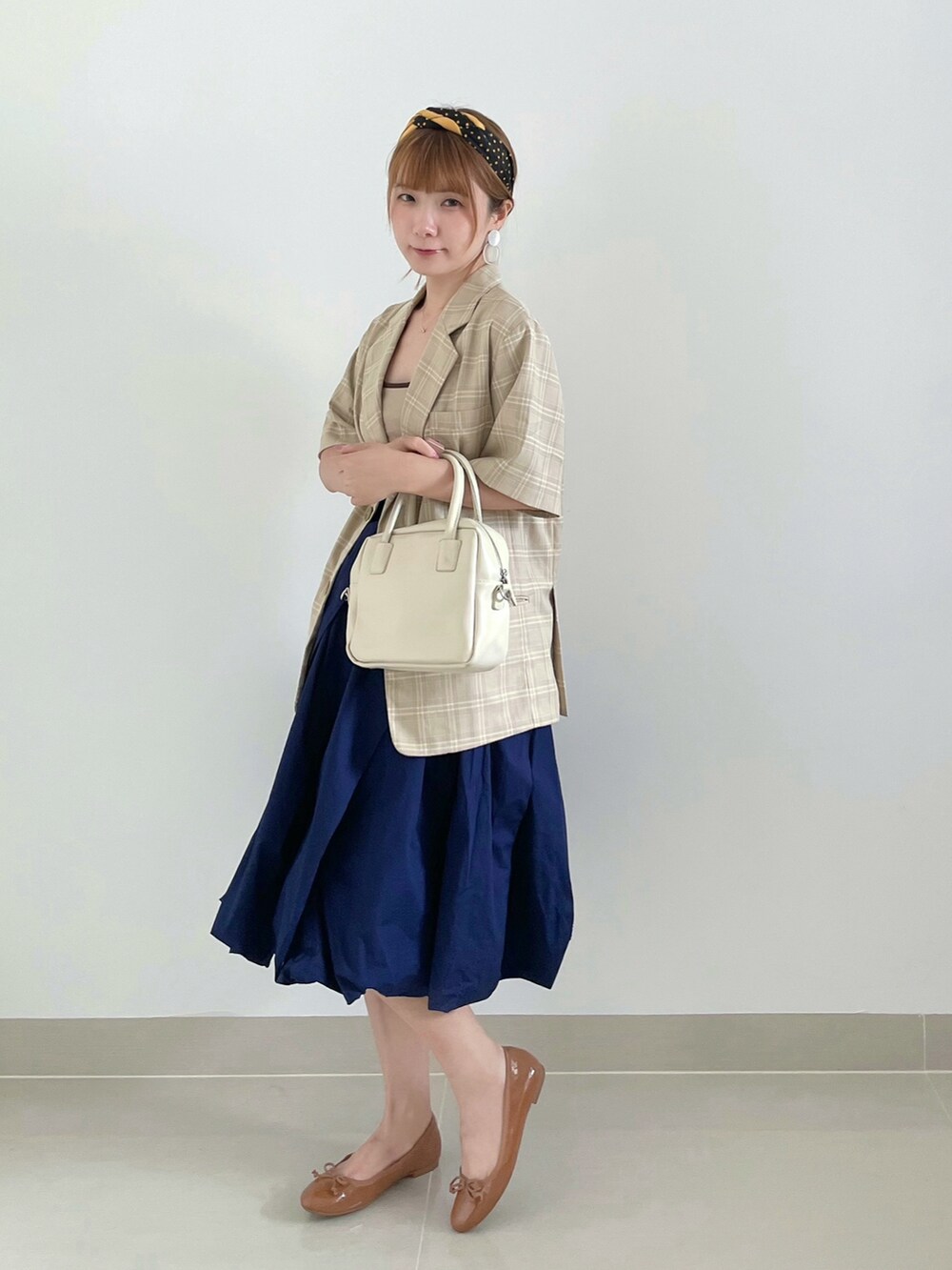 ブルー系のスカート、ベージュ系のトップス、イエロー系のバレエシューズを着用したレディースの夏コーディネートの2枚目の写真