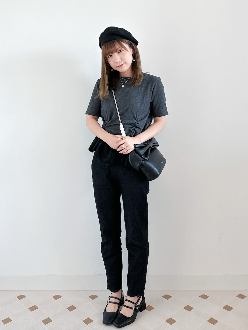 ブラック系のデニムパンツ、ブラック系のパンプス、グレー系のトップスを着用したレディースの夏コーディネートの2枚目の写真