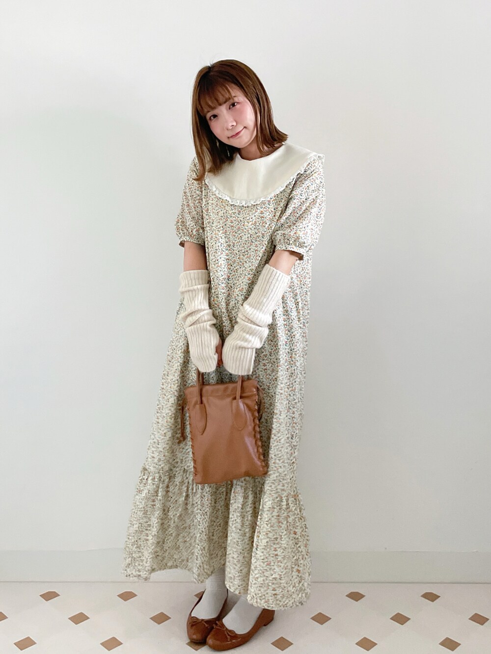 イエロー系のワンピース/ドレス、ブラウン系のショルダーバッグ、イエロー系のバレエシューズを着用したレディースの秋コーディネートの2枚目の写真