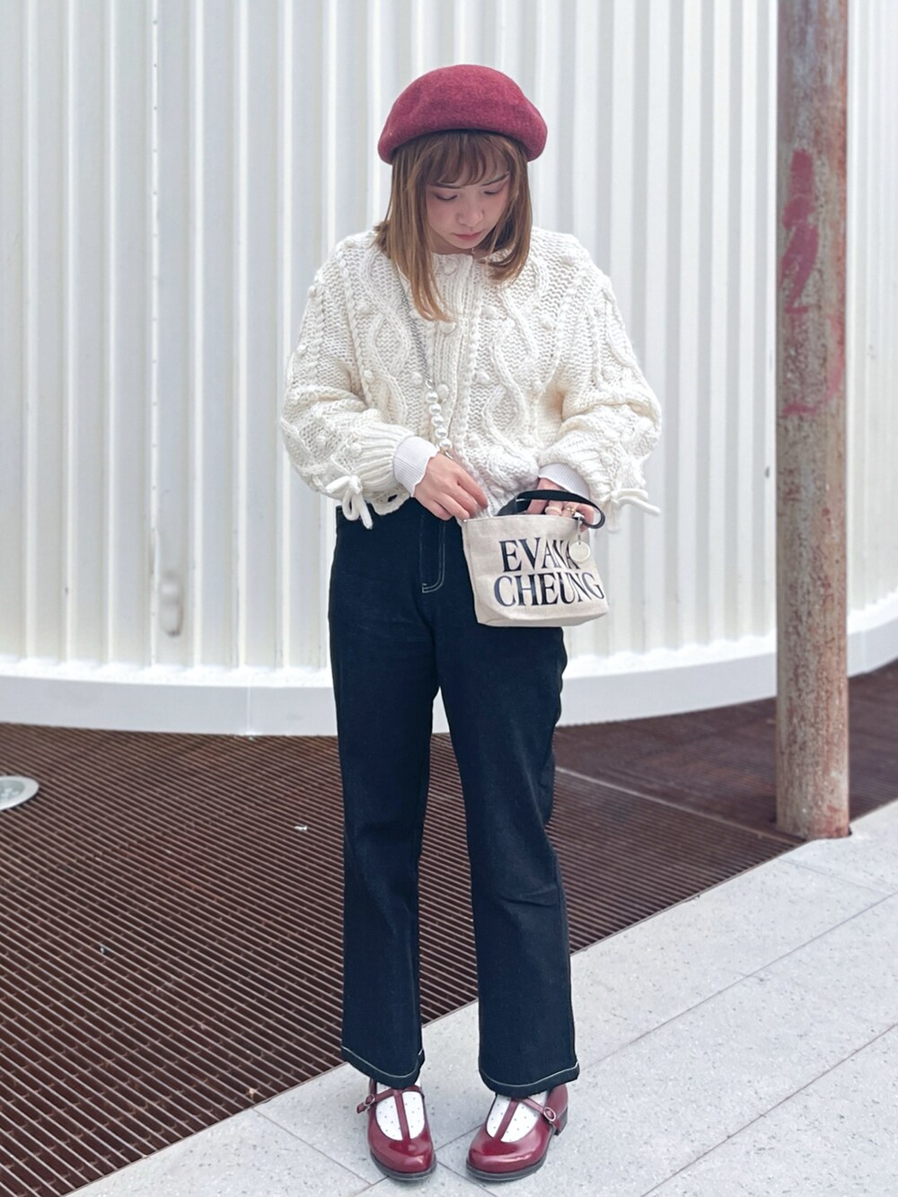 ホワイト系のカーディガン/ボレロ、ブラック系のデニムパンツ、レッド系のドレスシューズを着用したレディースの冬コーディネートの2枚目の写真
