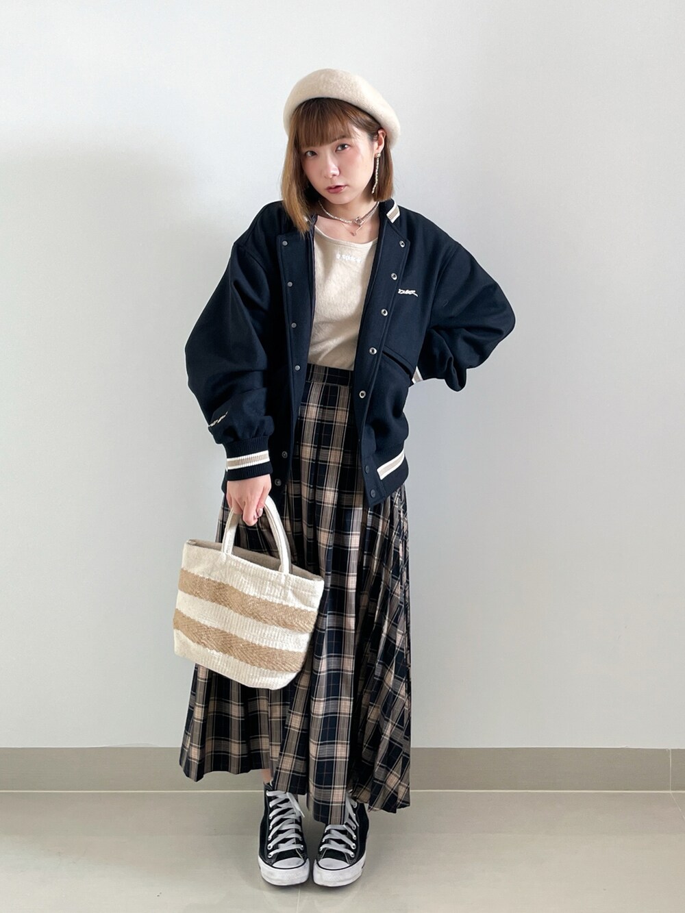 ブラック系のスニーカー、ベージュ系のバッグ、ブラック系のジャケット/アウターを着用したレディースの秋コーディネートの3枚目の写真