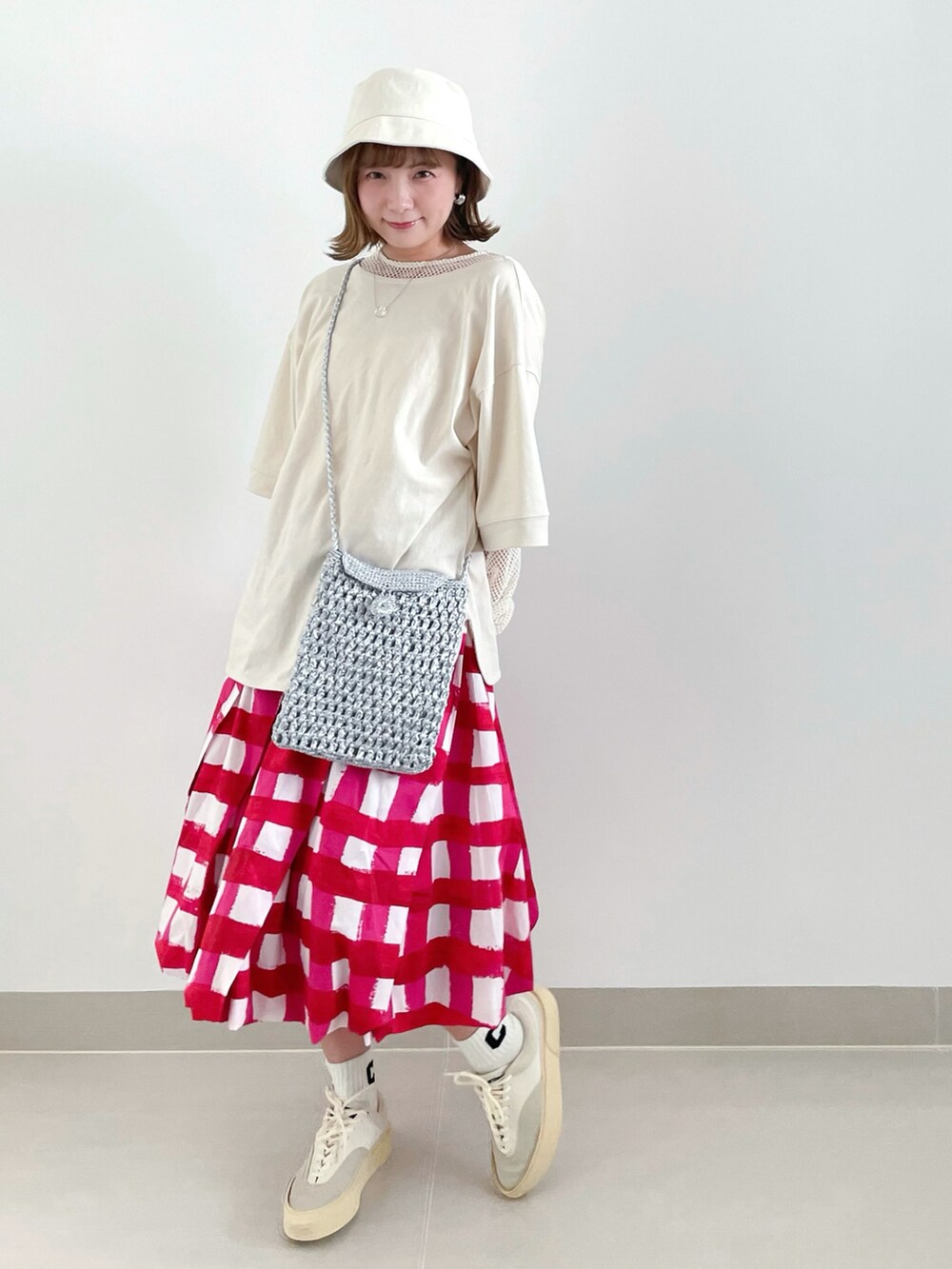 ホワイト系のTシャツ/カットソー、グレー系のショルダーバッグ、レッド系のスカートを着用したレディースの夏コーディネートの2枚目の写真