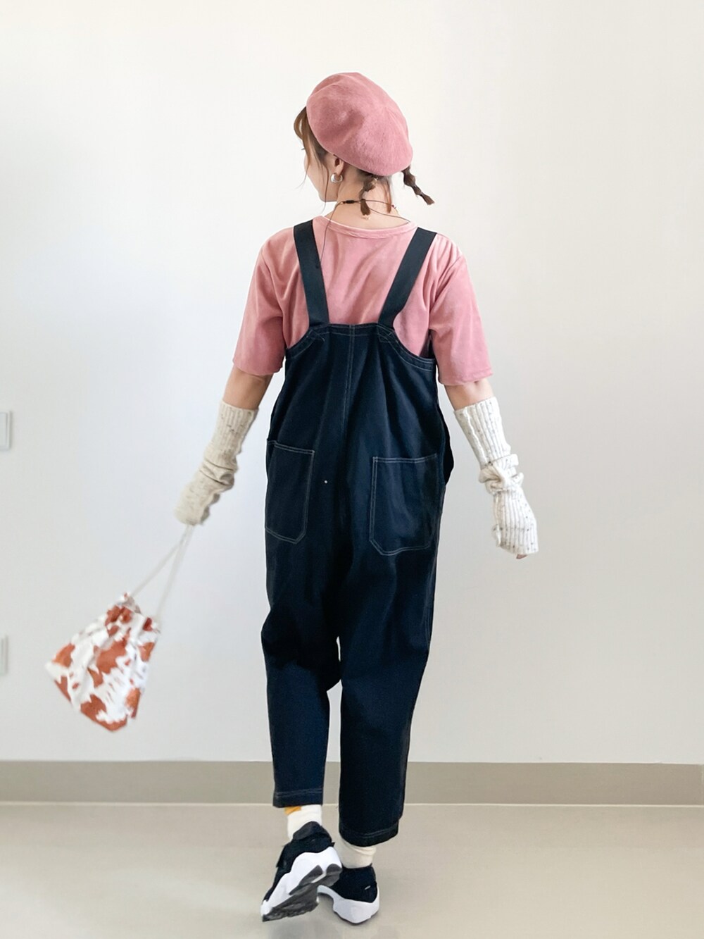 ピンク系のTシャツ/カットソー、ブラック系のサロペット/オーバーオール、ホワイト系のショルダーバッグを着用したレディースの秋コーディネートの2枚目の写真