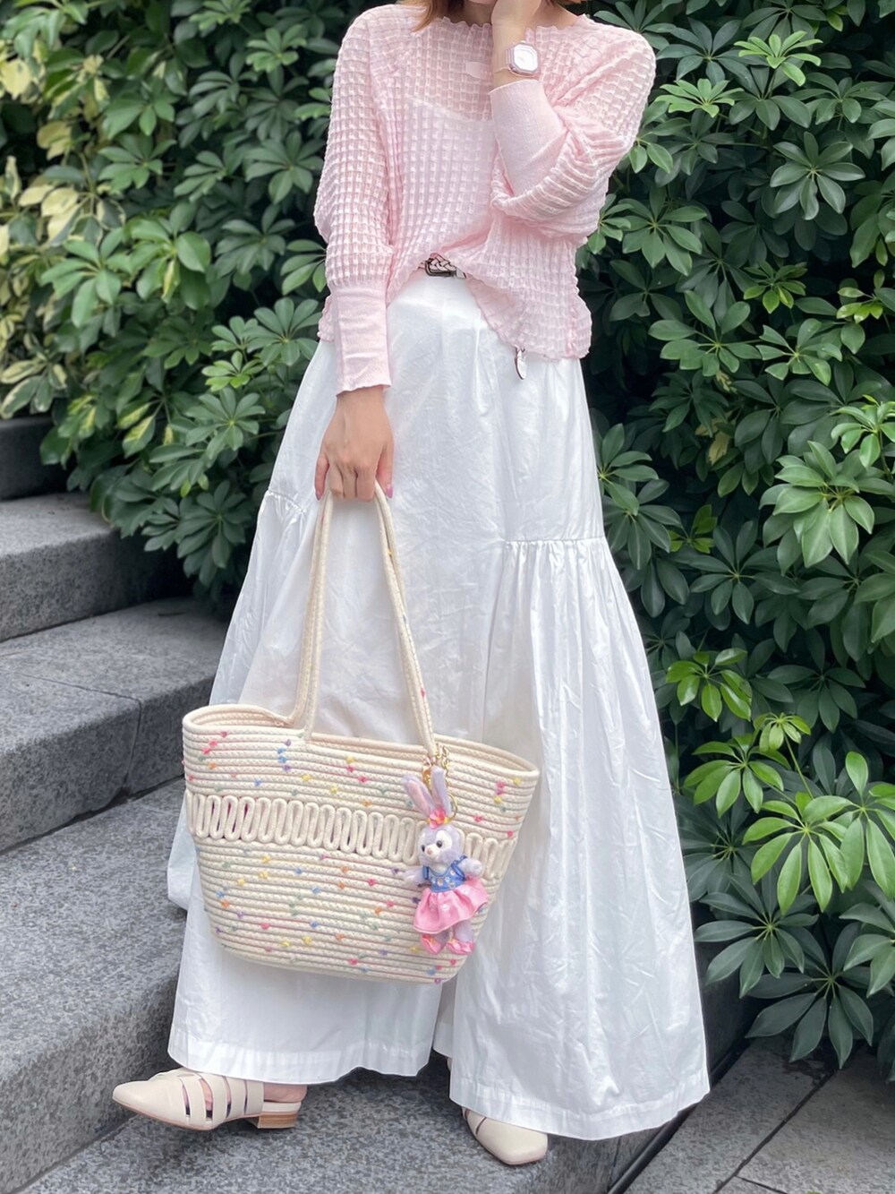 ピンク系のニット/セーター、ホワイト系のスカート、ホワイト系のサンダルを着用したレディースの夏コーディネートの2枚目の写真