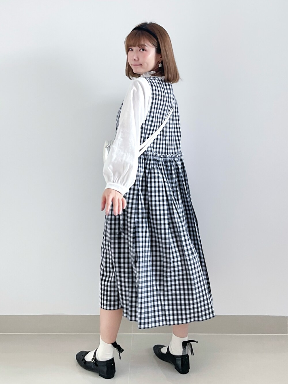 ホワイト系のバッグ、ブラック系のシューズ、ブラック系のワンピース/ドレスを着用したレディースの秋コーディネートの3枚目の写真