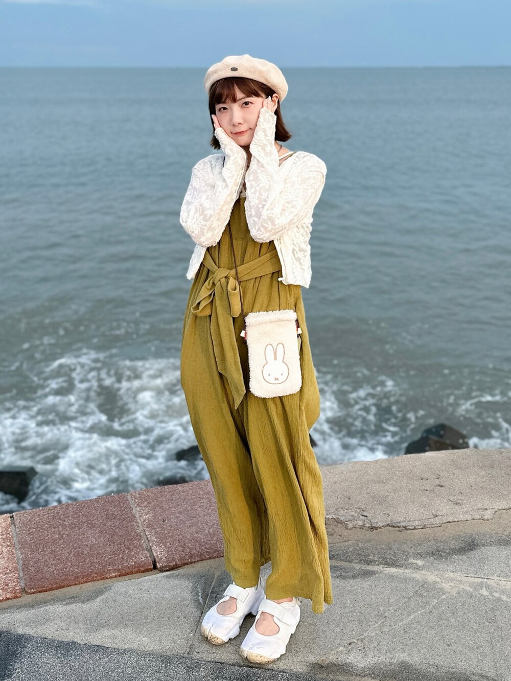 ホワイト系のTシャツ/カットソー、グリーン系のサロペット/オーバーオール、ベージュ系のスニーカーを着用したレディースの夏コーディネートの2枚目の写真