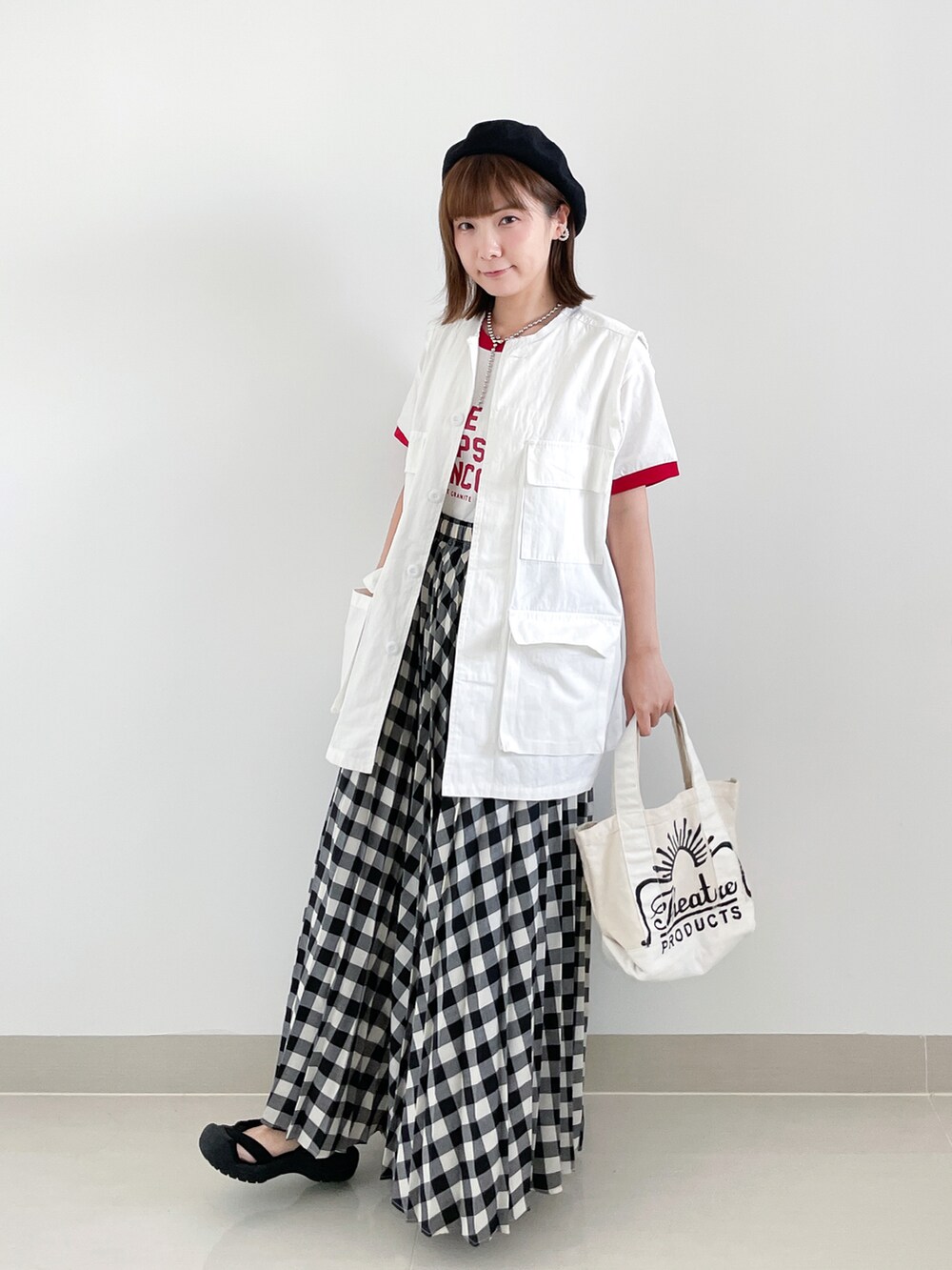 ホワイト系のスカート、ホワイト系のベスト、ホワイト系のTシャツ/カットソーを着用したレディースの夏コーディネートの2枚目の写真