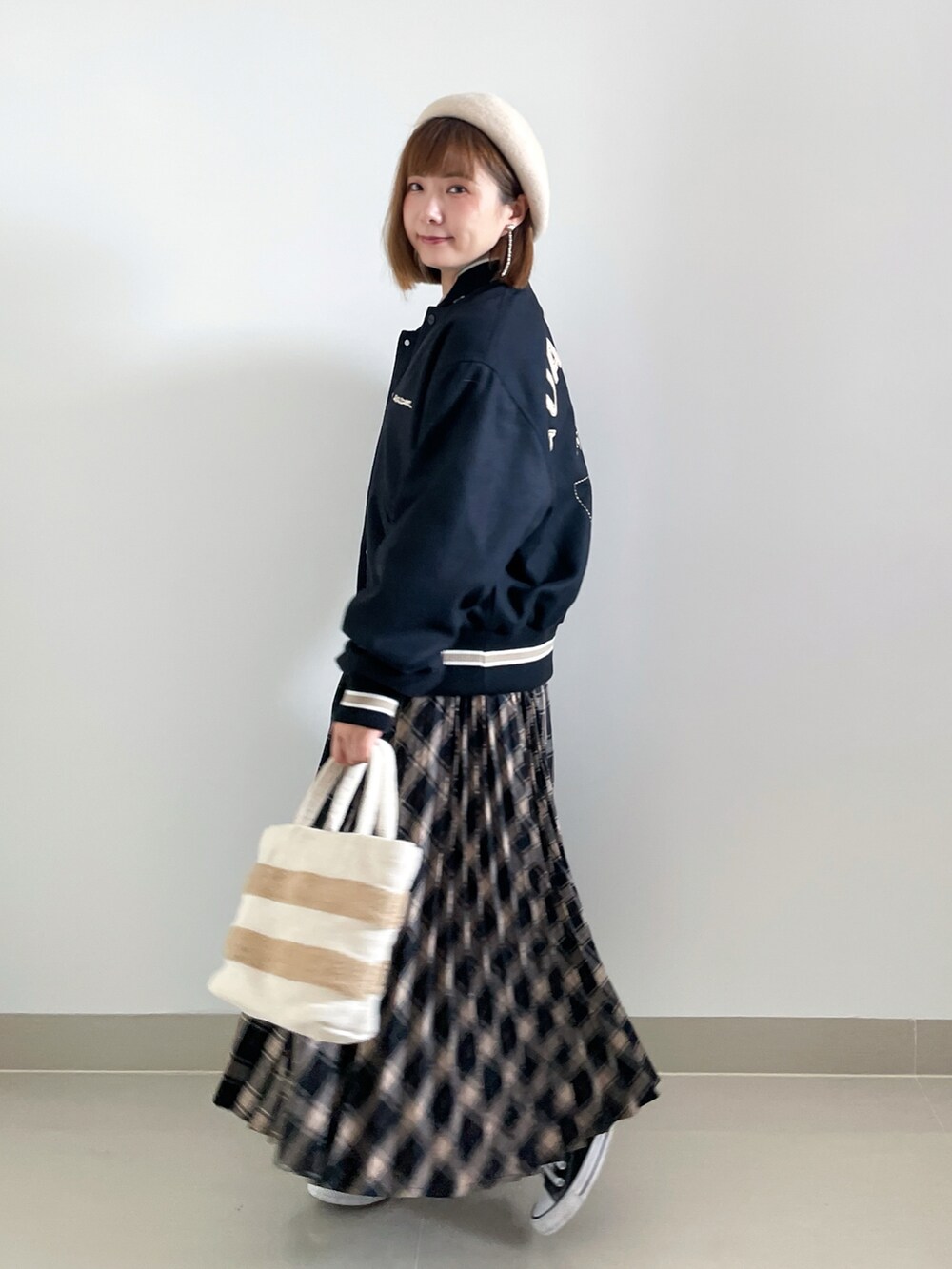 ブラック系のスニーカー、ベージュ系のバッグ、ブラック系のジャケット/アウターを着用したレディースの秋コーディネートの2枚目の写真