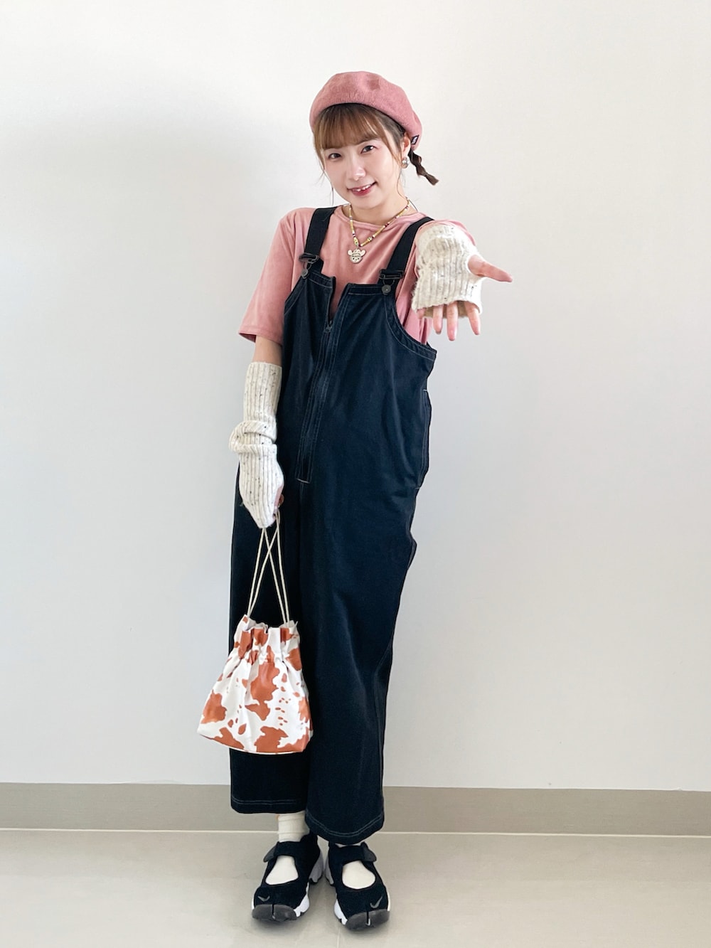 ピンク系のTシャツ/カットソー、ブラック系のサロペット/オーバーオール、ホワイト系のショルダーバッグを着用したレディースの秋コーディネートの3枚目の写真