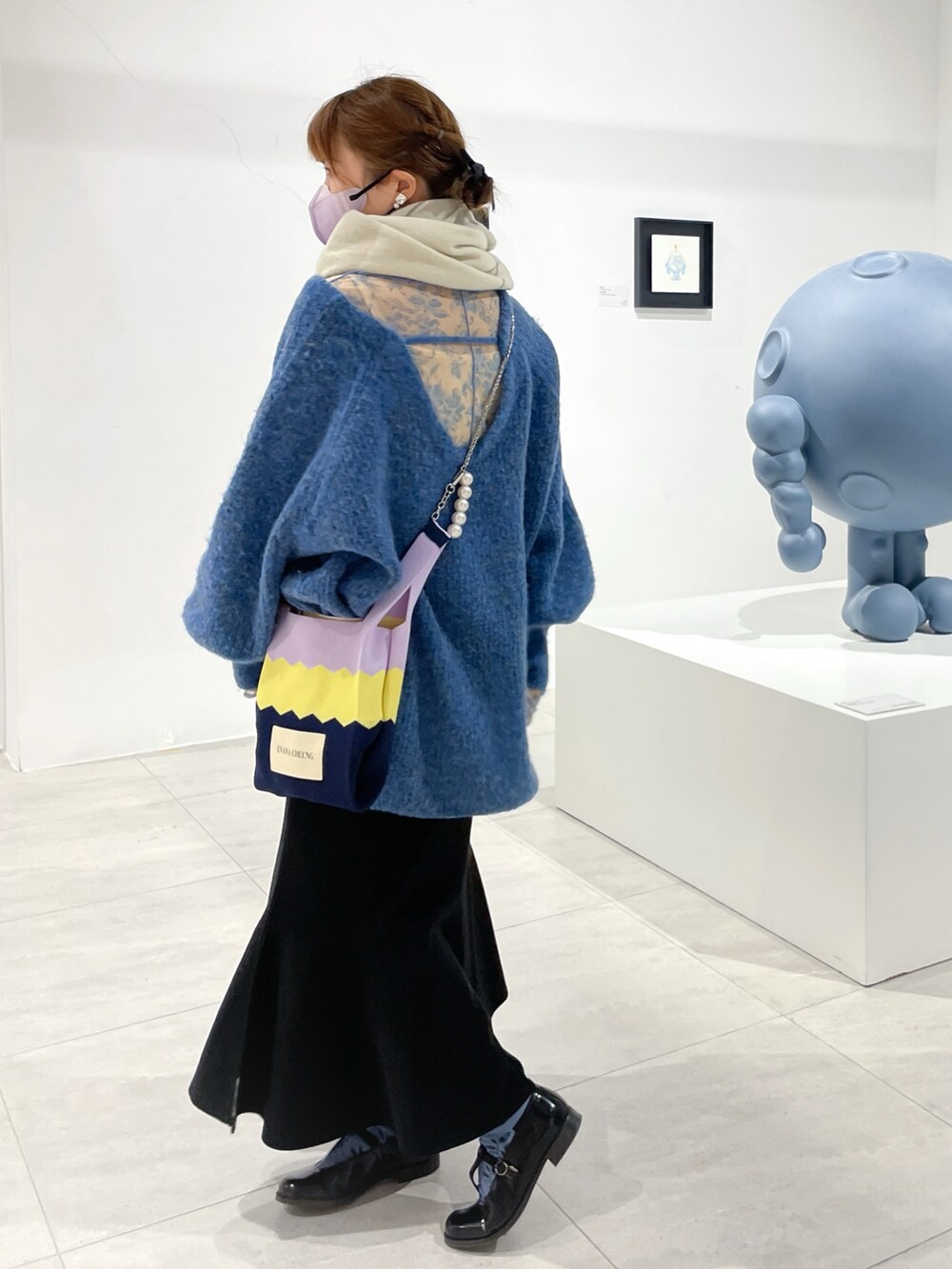 ブルー系のニット/セーター、ブラック系のスカート、ブラック系のドレスシューズを着用したレディースの冬コーディネートの2枚目の写真