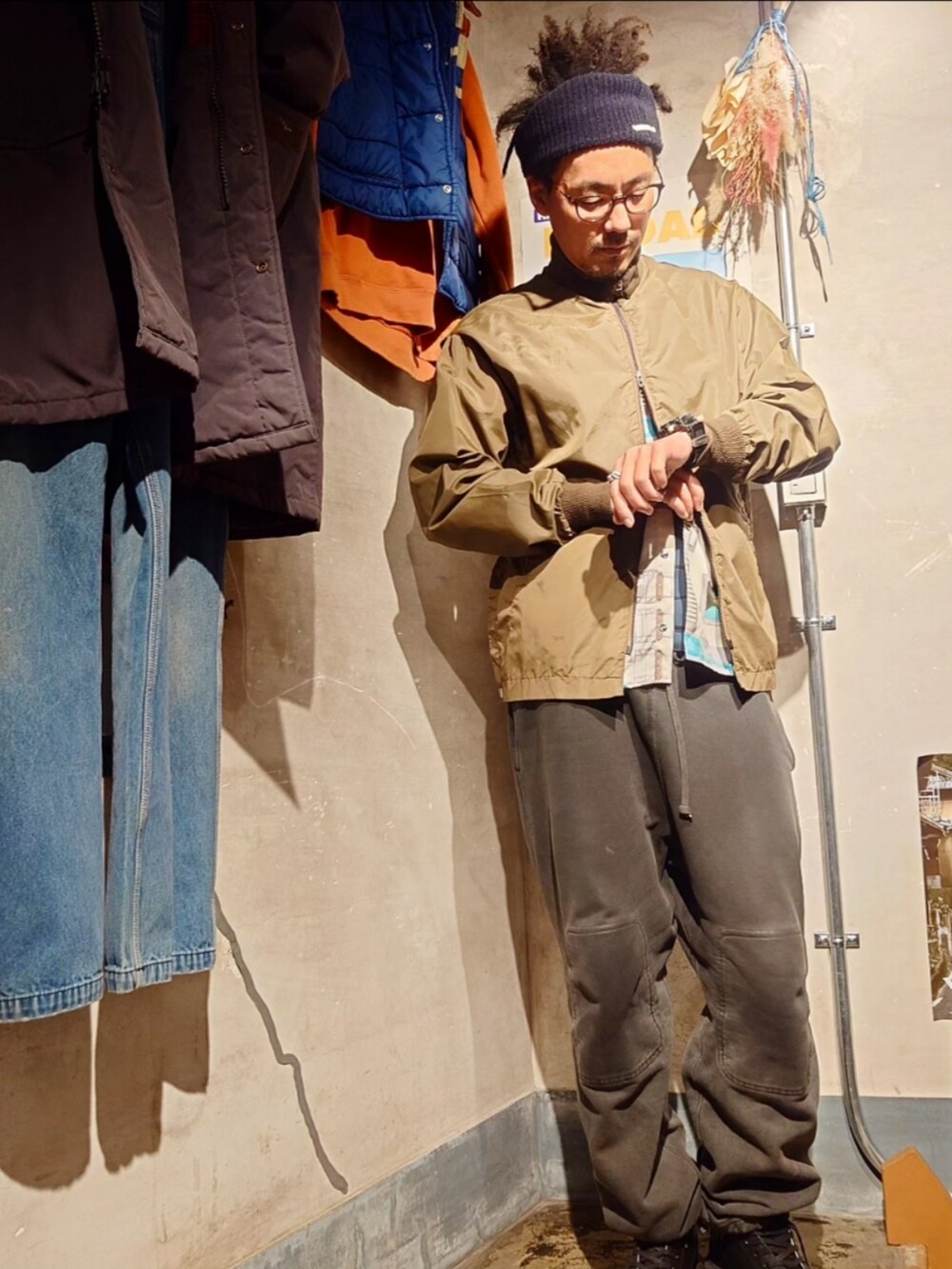 ブラウン系のナイロンジャケットを着用したメンズの春コーディネートの3枚目の写真