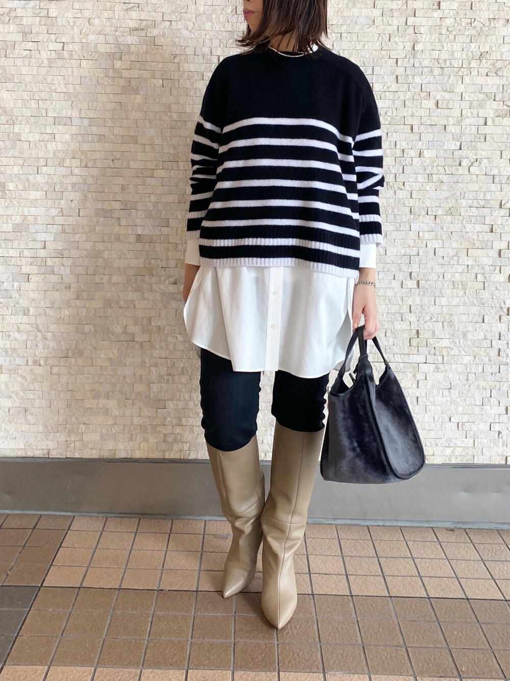 ブラック系のノーカラージャケット、ブラック系のニット/セーター、ホワイト系のシャツ/ブラウスを着用したレディースの秋コーディネートの2枚目の写真