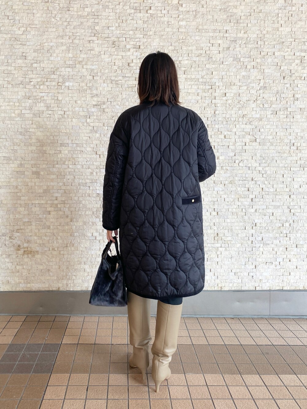 ブラック系のノーカラージャケット、ブラック系のニット/セーター、ホワイト系のシャツ/ブラウスを着用したレディースの秋コーディネートの3枚目の写真