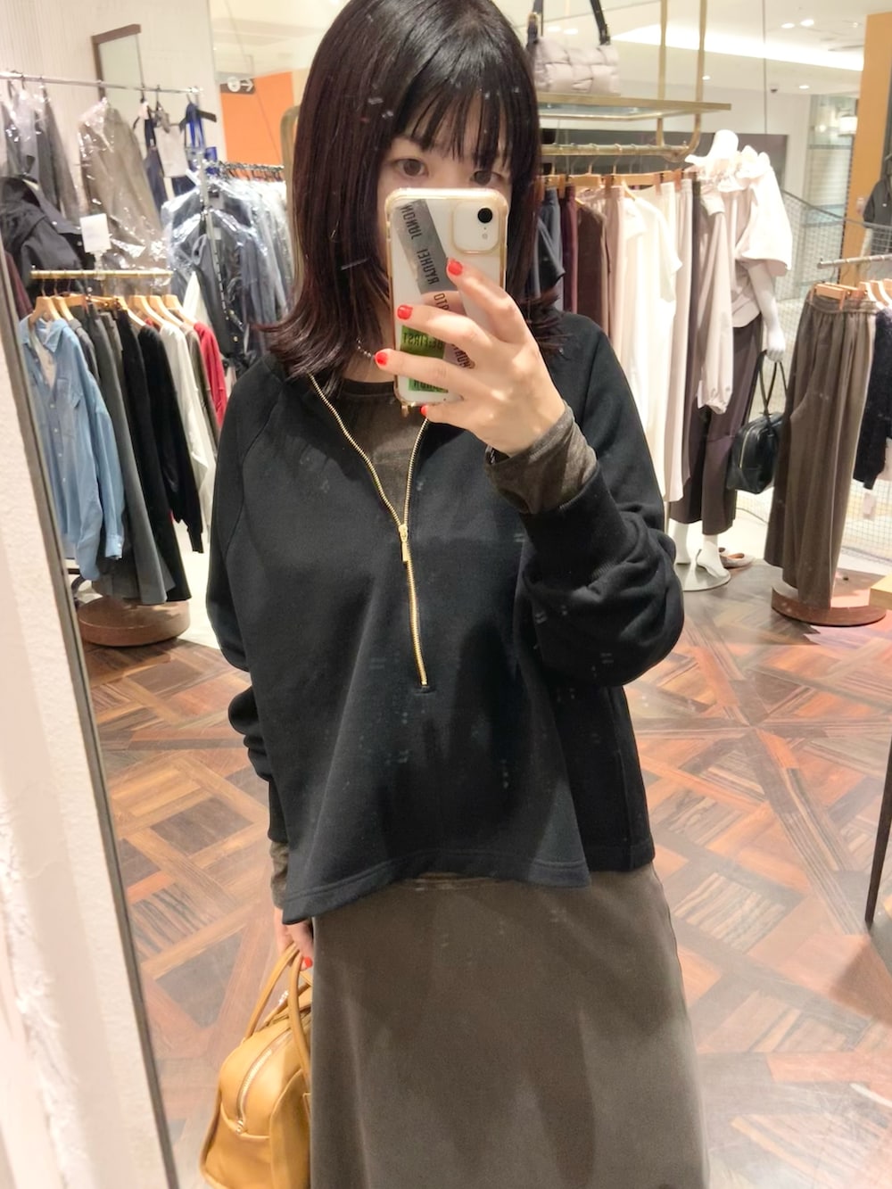ブラック系のスウェット、ブラウン系のTシャツ/カットソー、ブラウン系のスカートを着用したレディースの秋コーディネートの2枚目の写真