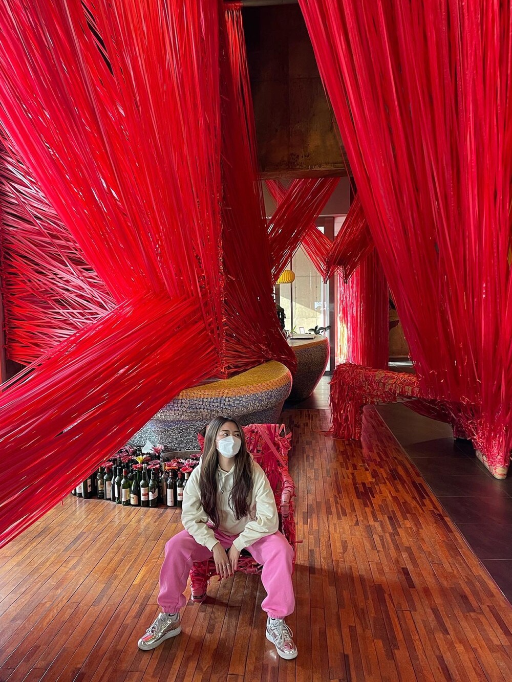 ベージュ系のパーカー、シルバー系のスニーカーを着用したレディースの秋コーディネートの2枚目の写真