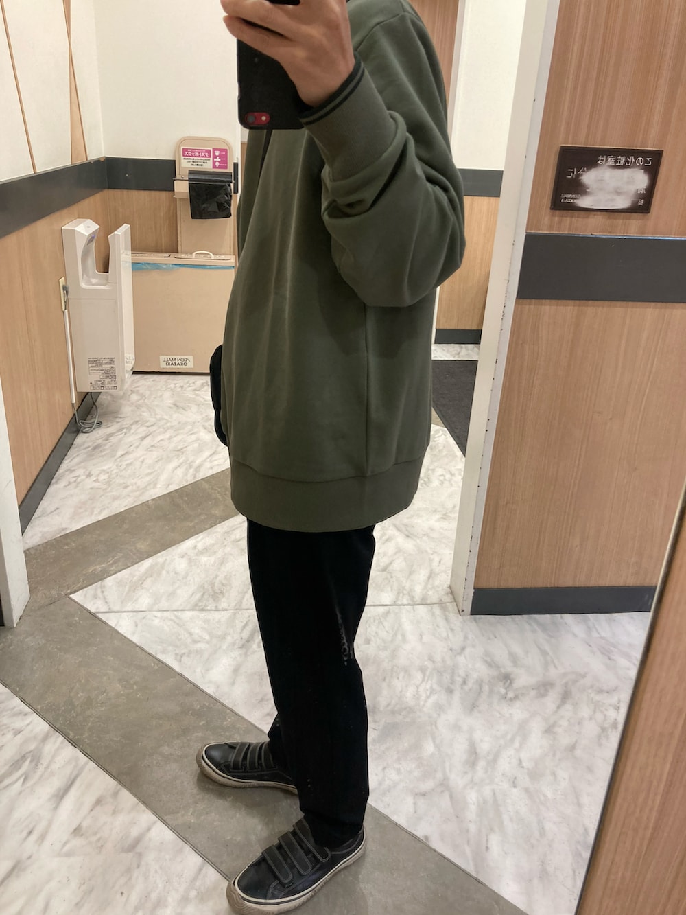 ブラック系のスニーカー、ブラック系のスラックス、ブラック系のショルダーバッグを着用したメンズの冬コーディネートの2枚目の写真